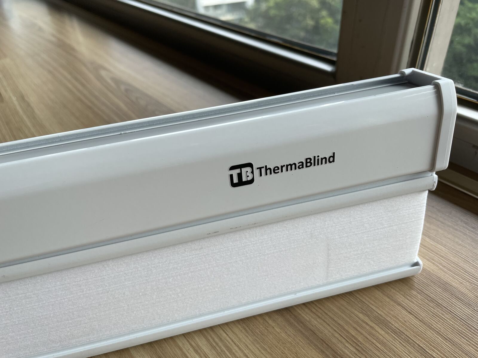 ThermaBlind metal header with logo, on a windowsill